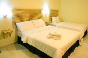 two beds in a hotel room with towels on them at HOTEL MESRA ALOR SETAR in Alor Setar