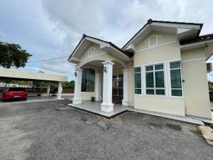 a house with a car parked in a parking lot at AmVilla in Kota Bharu