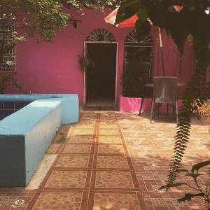 Casa con pared de color rosa y suelo de baldosa. en Funky Monkey, en Guayaquil