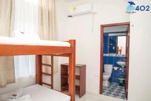 a room with a bunk bed and a bathroom with a toilet at Apartahotel Sueños Libres Necoclí in Necoclí