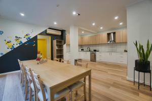 uma cozinha e sala de jantar com uma mesa de madeira e cadeiras em Dreamy Stays Accommodation - Private Rooms with Shared Bathrooms em Adelaide
