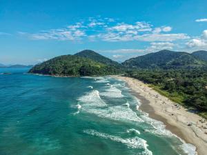 an aerial view of a beach with mountains in the background at Sintonia Surf Hostel e Bar in Ubatuba