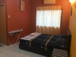 a bedroom with a bed and a window at Desa Ilmu Homestay in Kota Samarahan