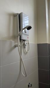 a shower in a bathroom with a hose at Umbai Homestay - Wak Sidin House in Melaka