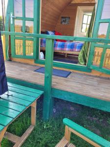 a bench on the front porch of a tiny house at Glamping Pod in St Austell Sleeps 2 with Spa Pool in Lanivet