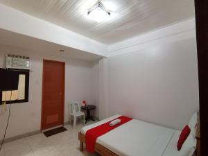 a bedroom with a bed and a television in it at Bohol Coop Tourist Inn in Tagbilaran City +8 photos