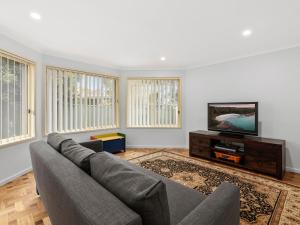 a living room with a couch and a flat screen tv at Southern Escape by Experience Jervis Bay in Sanctuary Point
