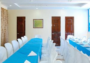 una sala de conferencias con una mesa azul y sillas blancas en Sky Garden Hotel by RedDoorz en Roxas City