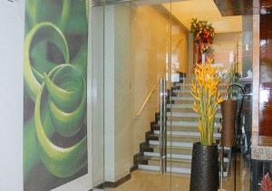 a hallway with a staircase with a vase of flowers at Sky Garden Hotel by RedDoorz in Roxas City