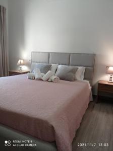 Un dormitorio con una cama grande con dos animales de peluche. en Sunshine Apartments, en Kato Daratso