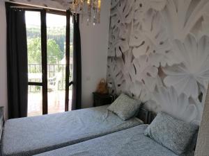 a bedroom with two beds and a chandelier at Albergue Puente para peregrinos in Puente la Reina