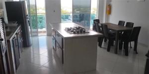 a kitchen with a stove and a table with chairs at Apartahotel Sueños Libres Necoclí in Necoclí