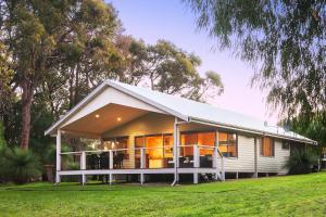 a white house with a gambrel roof at Acacia Chalets Margaret River in Margaret River Town