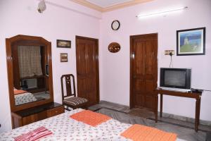 a bedroom with a bed and a tv and a mirror at anjani mansion in Hyderabad