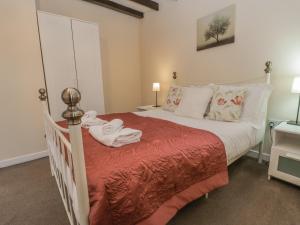 um quarto com uma cama branca e um cobertor vermelho em Robins Nest em Whitby
