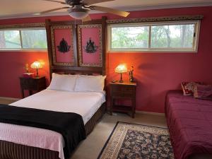 a bedroom with two beds and two windows at Tambaridge Bed & Breakfast in Eagle Heights