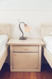 eine Lampe auf einem Nachttisch zwischen zwei Betten in der Unterkunft Engelhof in Weilheim an der Teck