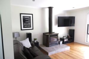 a living room with a couch and a fireplace at Belford House in Myrtleford