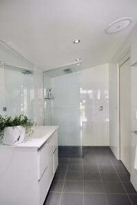a white bathroom with a shower and a sink at Belford House in Myrtleford
