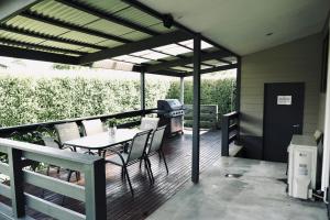 a patio with a table and chairs and a grill at Belford House in Myrtleford