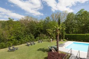 a backyard with a swimming pool and a palm tree at Art Hotel Pandos in Tabiano