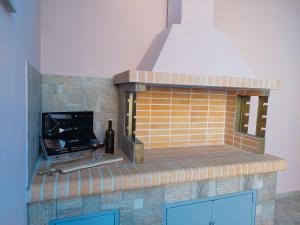 a brick fireplace with a bottle of wine and a glass at Royal Legend Suite in Souda