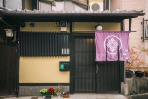 una puerta a un edificio con una bandera púrpura en él en 谷町君 星屋 清水家 京都清水寺二年坂, en Kioto