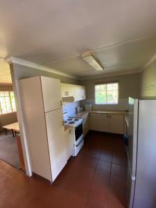 a kitchen with a white refrigerator and a stove at Under The Oak in Underberg