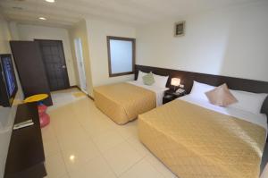 a hotel room with two beds and a television at 吉貝 新港景 亞泰民宿 編號133 in Baisha