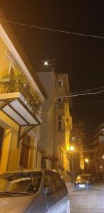 Un coche aparcado delante de un edificio por la noche en Roman Stadium Apartments, en Plovdiv
