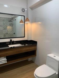 y baño con lavabo, espejo y aseo. en Executive Apartments San Isidro Business Zone en Lima
