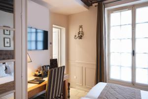 a room with a bed, chair and a window at Hotel Saint-Louis Marais in Paris