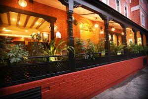 un restaurant avec un bâtiment en briques orné de plantes dans l'établissement Kumari Boutique Hotel, à Katmandou