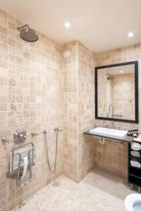 a bathroom with a shower and a sink and a mirror at Hotel Saint-Louis Marais in Paris