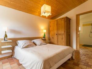 Schlafzimmer mit einem großen weißen Bett und einer Holzdecke in der Unterkunft Gîte Le Cellier, 3 pièces, 6 personnes - FR-1-306-891 in Le Cellier