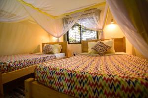 Rúm í herbergi á Cycad Entebbe Guest House