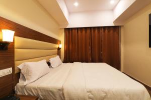 - une chambre avec un grand lit blanc dans l'établissement FabHotel Blueark, à Lucknow