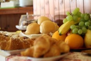 a table topped with plates of bread and fruit at Hotel Lu Pitrali in San Teodoro