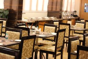 une rangée de tables et de chaises dans un restaurant dans l'établissement S R Continental, à Gulbarga