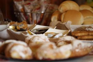 a table topped with different types of bread and pastries at Hotel Lu Pitrali in San Teodoro