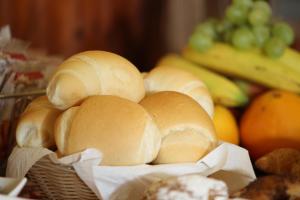 a bunch of bread in a basket with fruits and vegetables at Hotel Lu Pitrali in San Teodoro