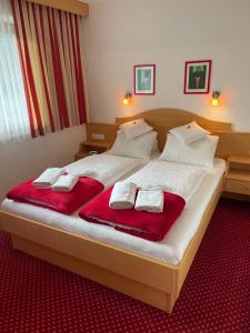a bedroom with a large bed with red towels on it at W2 Haus Ganghofer in Leutasch