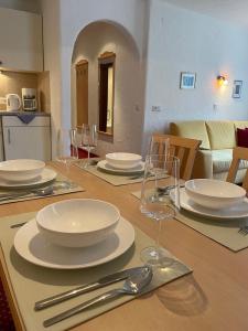 a wooden table with white plates and silverware on it at W2 Haus Ganghofer in Leutasch +26 photos