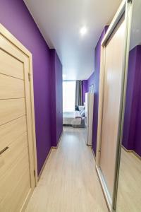 un pasillo vacío con paredes púrpuras y una puerta en "Sharm" Стильная студия на Броско, en Khabarovsk