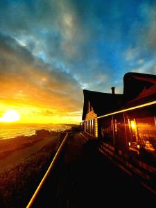 a building with the sunset in the background at Oyster Bay Beach Lodge in Oyster Bay