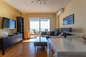 a living room with a couch and a tv at Apartment with sea view in Almuñécar