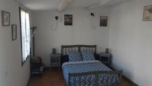 Schlafzimmer mit einem Bett mit blauer Decke in der Unterkunft L'ilot de Carpentras in Carpentras