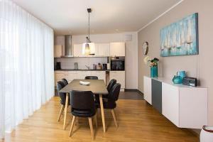 a kitchen and dining room with a table and chairs at Ferienwohnung-Saentis in Friedrichshafen