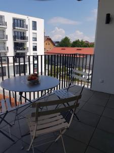 a table and chair on a balcony with a bowl of fruit at Ferienwohnung-Saentis in Friedrichshafen