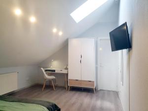 a bedroom with a bed and a desk and a tv at Kambarių nuoma - Pašakarniai SAURIDA in Akmenė